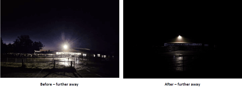 Night scene of a lit building in a fenced area; bright light at left, wet ground reflects light.